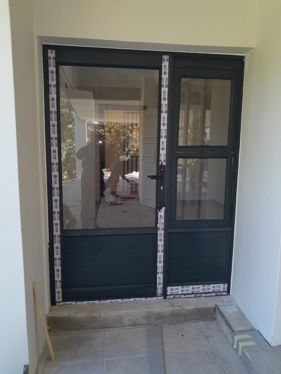 charcoal aluminium hinged door with protective tape, fresh install