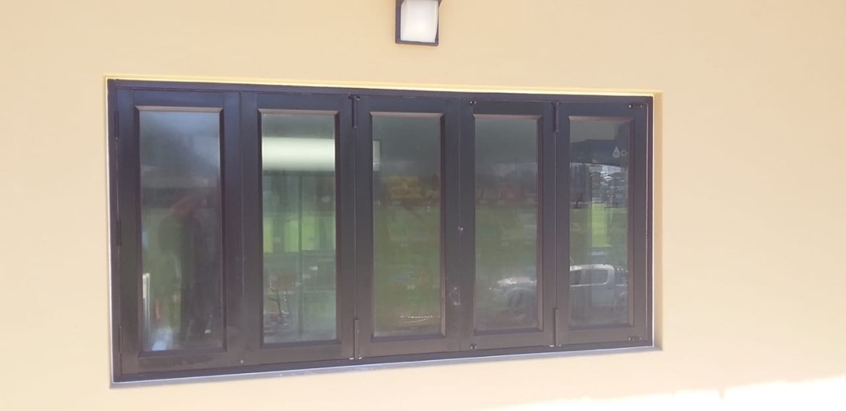 charcoal aluminium bi-fold window, exterior shot on cream wall
