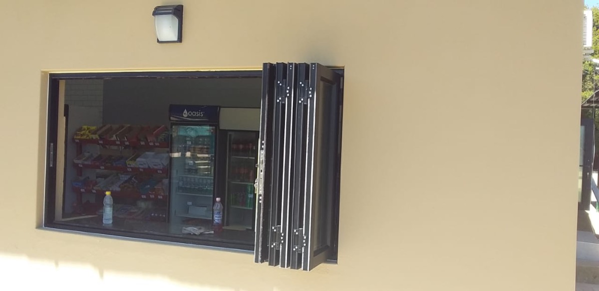 charcoal stacking folding doors, half-open on a commercial building